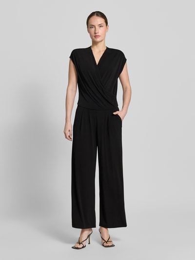 Vrouwenmodel draagt Jumpsuit in Wickel-Optik mit V-Ausschnitt van ROBE LÉGÈRE, zwart, materiaalmix met stretch, regular fit, wikkellook, V-hals, ruglengte maat 36: 49 cm, borstwijdte maat 36: 42 cm, totale lengte maat 36: 147 cm, binnenbeenlengte maat 36: 63 cm, volledige vooraanzicht.
