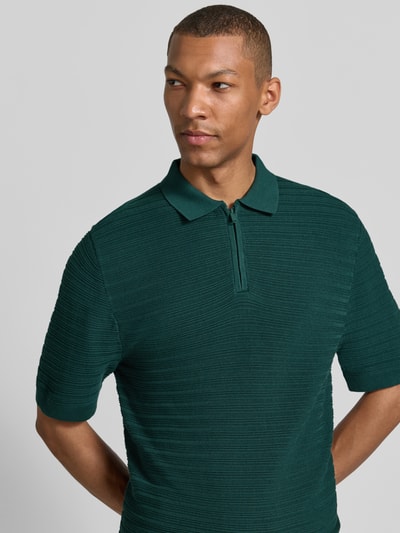 Männermodel trägt Regular Fit Poloshirt mit kurzem Reißverschluss von MCNEAL, Baumwoll-Mix mit Viskose-Anteil, Strukturmuster, Nahaufnahme Oberkörper.