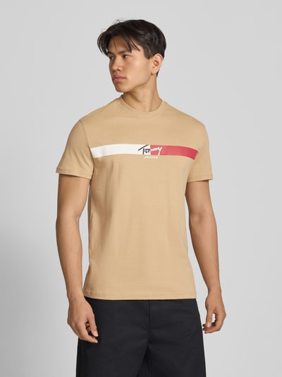 Männermodel trägt Regular Fit T-Shirt aus reiner Baumwolle von Tommy Jeans, Optik: Unifarben, Label-Print, Ganzkörperansicht von vorne.