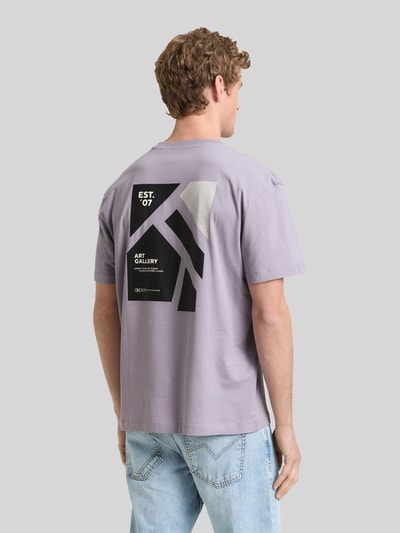 Männermodel trägt relaxed fit T-shirt aus reine katoen van Tom Tailor Denim, effen lila met labelprint, korte mouw, rugaanzicht