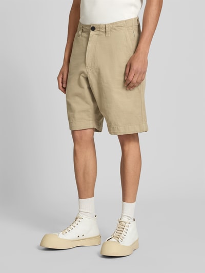 Männermodel trägt Straight Fit Bermuda mit Eingrifftaschen von ANNARR in Beige, Knielänge, Nahaufnahme Oberkörper bis Knie