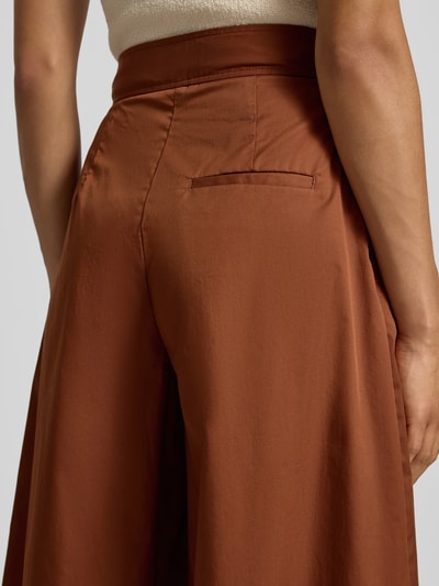 Frauenmodel trägt Wide Leg Stoffhose mit Raffungen von Stefanel aus elastischem Baumwoll-Mix in Braun, Detailaufnahme Rückansicht.