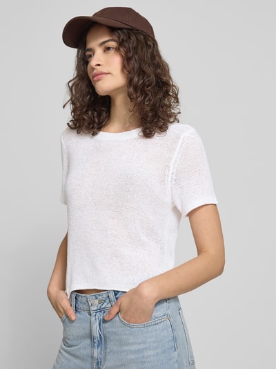 Frauenmodel trägt Regular Fit Strickpullover mit kurzen Ärmeln Modell 'SUNNY' von Only, unifarben weiß, Rundhals, Rollsaum, Strick, Nahaufnahme Oberkörper.