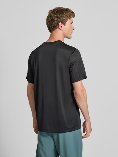 Mężczyzna nosi T-Shirt mit Logo-Print und Rundhalsausschnitt von NIKE TRAINING, czarny kolor, prosty krój, tylny widok całej sylwetki, długość tyłu w rozmiarze M: 66 cm.