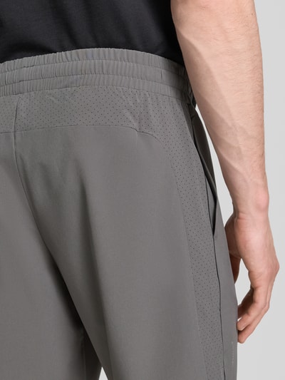 Männermodel trägt Shorts mit Logo von EA7 Emporio Armani in Grau, Material-Mix mit Stretch-Anteil, Nahaufnahme Rückansicht.