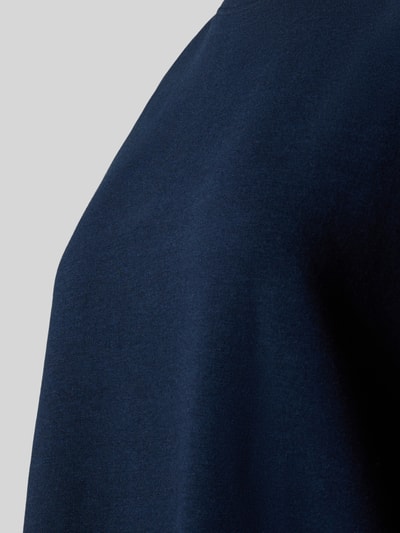 Frauenmodel trägt Relaxed Fit Pyjama-Oberteil mit Rundhalsausschnitt von Christian Berg Woman aus dunkelblauem Baumwoll-Mix mit Stretch-Anteil, Detailaufnahme.