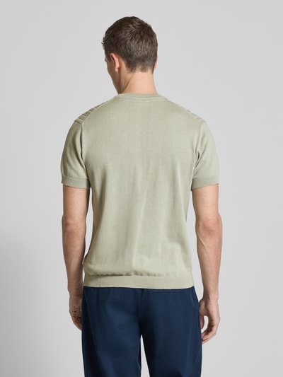 Männermodel trägt T-Shirt mit Zopfmuster von Lindbergh in Beige, reine Baumwolle, Strick-Optik, gerader Schnitt, Ganzkörperansicht Rückansicht.