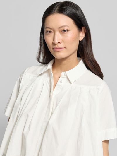 Frauenmodel trägt Bluse mit verdeckter Knopfleiste Modell 'SKYMA' von YAS aus Reiner Bio-Baumwolle, Loose-Fit, Kentkragen, Nahaufnahme Oberkörper.