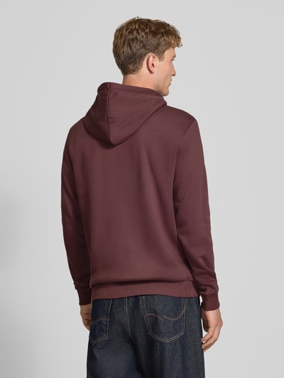 Männermodel trägt Regular Fit Hoodie aus Baumwoll-Mix Modell 'CERES' von ONLY & SONS in Dunkelrot, glatte Struktur, Ganzkörperansicht Rückansicht.