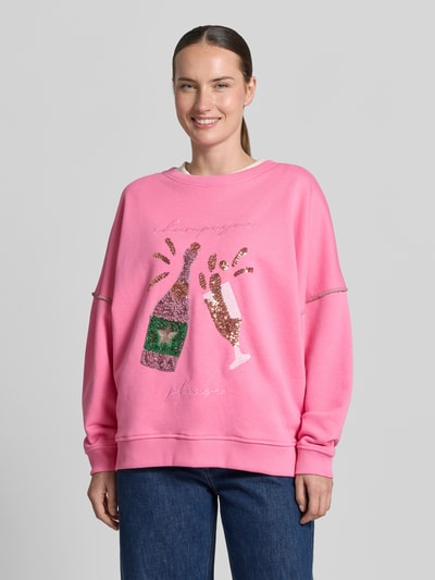 Frauenmodel trägt Oversized Sweatshirt aus reiner Baumwolle von miss goodlife in Pink mit Pailettenbesatz, Statement-Stitching, elastische Abschlüsse, Ganzkörperansicht von vorne.