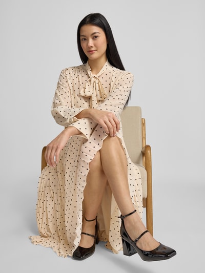 Vrouwenmodel draagt Strikblouse in all-over look model 'Bo' van JOOP!, regular fit, ruglengte 64 cm, mouwlengte 56 cm, voorkant volledige lichaamsweergave.