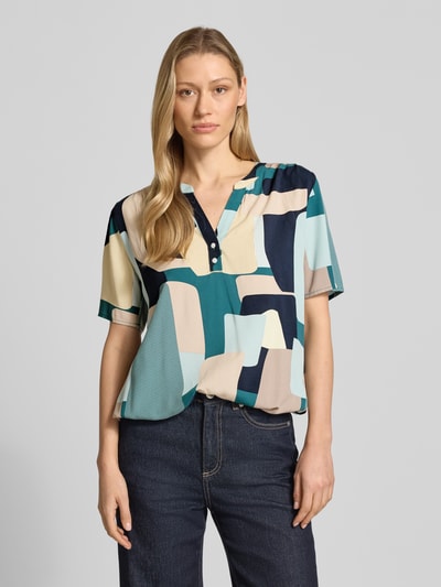 Frauenmodel trägt Regular Fit Blusenshirt aus reiner Viskose von Tom Tailor in mehrfarbigem Popeline mit kurzem Arm und V-Ausschnitt, Ganzkörperansicht von vorne.