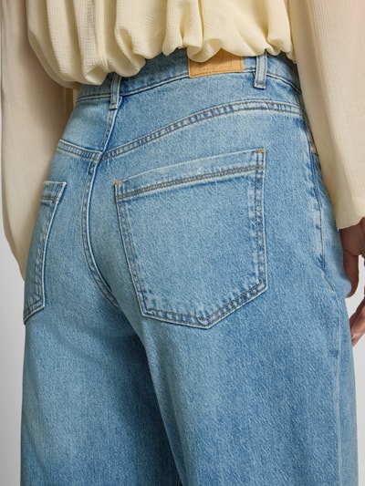 Kobiece model prezentuje jeansy z wpuszczanymi kieszeniami Jeans mit Eingrifftaschen Modell 'Caia iconic' od someday., mieszanka bawełny i lyocellu, szerokie nogawki, szerokość w rozmiarze 36: 39 cm, długość wewnętrzna nogawki w rozmiarze 36: 77 cm, zbliżenie na tył