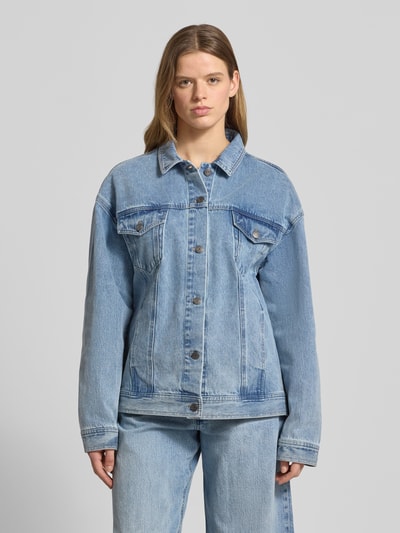 Frauenmodel trägt Jeansjacke mit rückseitigem Label-Patch von Karo Kauer aus Reine Baumwolle im Loose-Fit mit Kentkragen, Knopfleiste, Pattentaschen mit Knopfverschluss und seitlichen Eingrifftaschen, Hellblau, strukturierte Denim-Textur, Ganzkörperansicht von vorne. Rückenlänge 68 cm, Schulterbreite 60 cm, Brustweite 58 cm, Ärmellänge 60 cm, Größe S.
