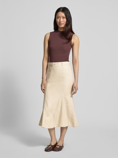 Frauenmodel trägt Midirock mit Gürtel Modell 'RYAN' von Guess aus reiner Viskose in A-Linie, cremefarbene Textur, Ganzkörperansicht von vorne.