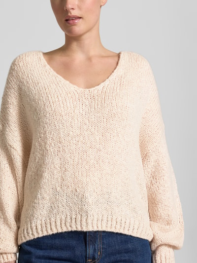 Vrouwenmodel draagt Oversized gebreide pullover met mohairgehalte van Oui in lichtbeige met ribboorden, Materiaalmix, V-hals, ruglengte maat 36: 37 cm, mouwlengte maat 36: 48 cm, Nahaufnahme bovenlichaam.