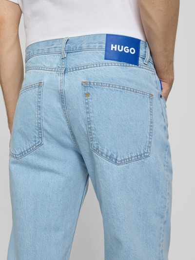 Mężczyzna nosi Straight Fit Jeans aus reiner Baumwolle Modell 'JONAH' von Hugo Blue, jasnoniebieski denim, label patch, 5 kieszeni, detaliczne ujęcie z tyłu.