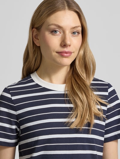 Modelka kobieca nosi Regular Fit T-Shirt aus reiner Baumwolle od s.Oliver RED LABEL, efekt: wzór na całej powierzchni, krój regular fit, naszywka z logo, okrągły dekolt, krótki rękaw, wykończenie materiału: dżersej, bawełna, zbliżenie na górną część ciała z przodu.