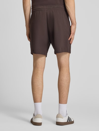 Männermodel trägt Regular Fit Sweatshorts mit Baumwoll-Anteil von adidas Originals, Optik: Unifarben, Waffelstruktur, Ganzkörperansicht Rückansicht.