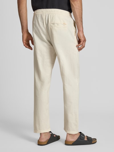 Männermodel trägt Relaxed Fit Hose aus Baumwoll-Leinen-Mix Modell 'KANE' von Jack & Jones in Beige mit Gesäßtasche und elastischem Bund, Ganzkörperansicht Rückansicht. Kontext: Herren Hose, Baumwoll-Leinen-Mix, Relaxed Fit, elastischer Bund, Tunnelzug, Gesäßtasche, Bundweite bei Größe M: 41 cm, Innenbeinlänge bei Größe M: 77 cm.