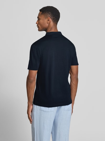 Männermodel trägt Slim Fit Poloshirt mit Stehkragen Modell 'LOUIS' von Drykorn, dunkelblau, glatte Struktur, Ganzkörperansicht Rückansicht. Baumwoll-Modal-Mix, Rückenlänge Größe M 69 cm.