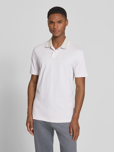 Männermodel trägt Relaxed Fit Poloshirt aus reiner Baumwolle Modell 'PEOXFORDNEW' von BOSS in mehrfarbig mit Logo Print, Nahaufnahme Oberkörper.