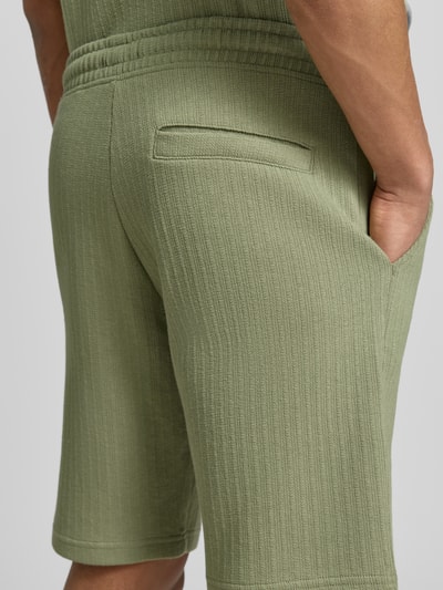 Männermodel trägt Regular Fit Shorts mit Tunnelzug von MCNEAL aus Baumwoll-Mix mit Stretch-Anteil, Eingrifftaschen, Gesäßtasche, Detailaufnahme.