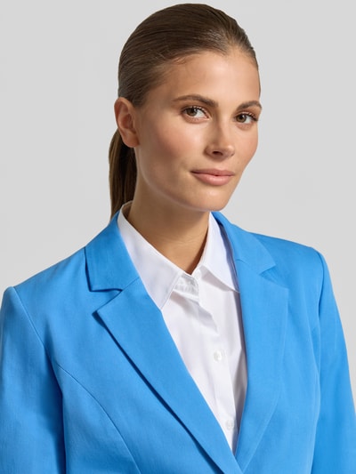 Frauenmodel trägt Blazer mit Pattentaschen und Reverskragen von More & More in Blau, Baumwoll-Mix mit Stretch-Anteil, Nahaufnahme Oberkörper.