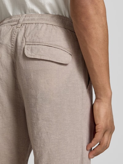 Männermodel trägt Hose aus Leinen-Baumwoll-Mix mit elastischem Bund von Lindbergh in Beige, Regular-Fit, Detailaufnahme Rückansicht, Eingrifftaschen, Bundweite 40 cm, Innenbeinlänge 79 cm, Größe M.