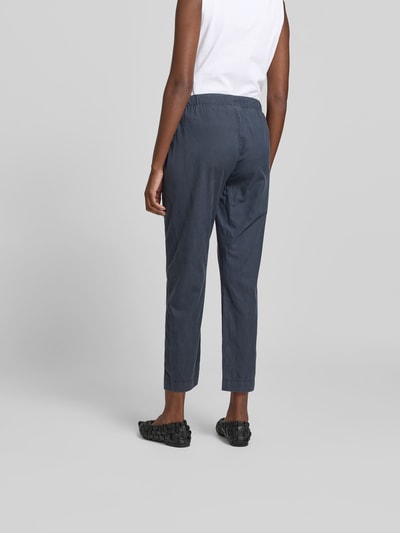 Frauenmodel trägt Stoffhose mit Lyocell-Anteil von Juvia in Dunkelblau, elastischer Bund, Straight fit, verkürzt, Ganzkörperansicht Rückansicht.