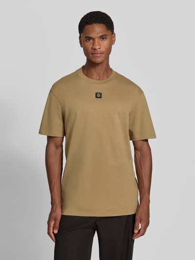 Männermodel trägt Regular Fit T-Shirt aus reiner Baumwolle Modell 'Dalile' von HUGO in Beige, glatte Textur, Ganzkörperansicht von vorne, Herren T-Shirt von HUGO.