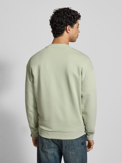 Männermodel trägt Regular Fit Sweatshirt aus reiner Baumwolle Modell 'NIEROFIX_CREW' von Hugo Blue, Optik: Unifarben, Ganzkörperansicht Rückansicht.