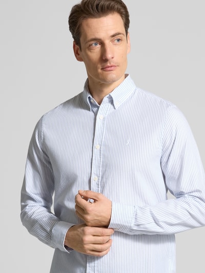 Männermodel trägt Regular Fit Freizeithemd aus reiner Bio-Baumwolle Modell 'QUAASA' von Armedangels, hellblau-weiß gestreift, Knopfleiste, Nahaufnahme Oberkörper.