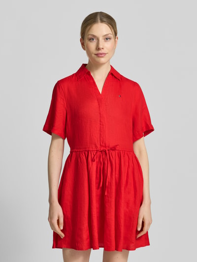 Frauenmodel trägt Ausgestelltes Freizeitkleid aus reinem Leinen von Tommy Hilfiger in Uni-Rot mit V-Ausschnitt, kurzarm, Ganzkörperansicht von vorne.