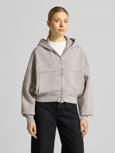 Frauenmodel trägt Sweatjacke mit Zweiwege-Reißverschluss Modell 'RANERA' von Drykorn, Reine Baumwolle, Relaxed-Fit, Kapuze, Ganzkörperansicht von vorne.