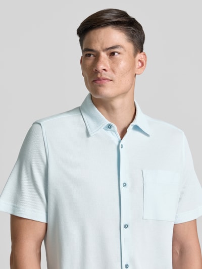 Männermodel trägt Regular Fit Freizeithemd aus Baumwoll-Mix von s.Oliver RED LABEL in Hellblau, Waffelstruktur, Nahaufnahme Oberkörper.