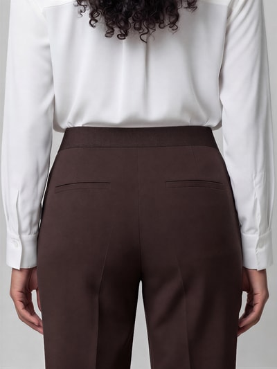 Frauenmodel trägt Regular Fit Culotte mit Bügelfalten Modell 'CAMERON' von CAMBIO in Dunkelbraun, glatte Textur, Ganzkörperansicht Rückansicht. Damen Culotte von CAMBIO.