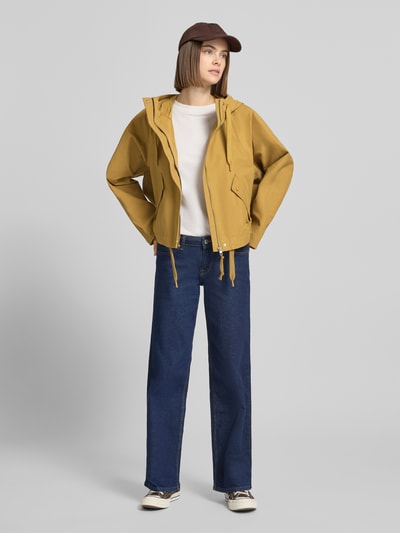 Vrouwenmodel draagt Regular Fit Parka uit katoenmix van Marc O'Polo Denim in effen mosterdgeel met capuchon en klepzakken, volledige vooraanzicht.