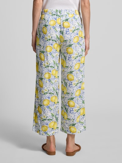 Frauenmodel trägt Caprihose aus Viskose im Allover-Look von Christian Berg Woman, gelbes Zitronenmuster, lockerer Schnitt, Ganzkörperansicht Rückansicht.