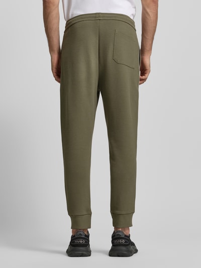Männermodel draagt Regular Fit Sweatpants uit katoenmix Model 'JOIN HADIKO' van BOSS Green, effen kleur, piqué, elastische boord, steekzakken, persplooien, tunnelkoordsluiting, zij-aanzicht, volledige lichaamsopname achterkant.