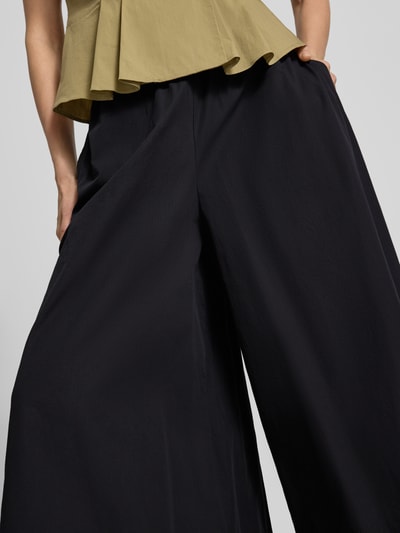 Frauenmodel trägt Wide Fit Stoffhose mit elastischem Bund Modell 'Sunna' von My Essential Wardrobe, Falten-Optik, Nahaufnahme Unterkörper. Bundweite bei Größe 36: 36 cm, Innenbeinlänge bei Größe 36: 58 cm.