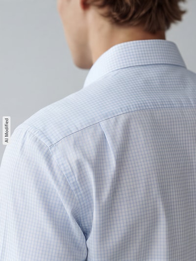 Männermodel trägt Regular Fit Businesshemd aus reiner Baumwolle von Seidensticker mit feinem, hellblauem Karomuster, Detailaufnahme Rückansicht. Herren Businesshemd von Seidensticker.