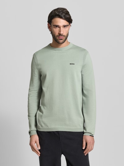 Männermodel trägt Regular Fit Strickpullover aus reiner Baumwolle Modell 'EVER-X' von BOSS Green in Hellgrün, Ganzkörperansicht von vorne.