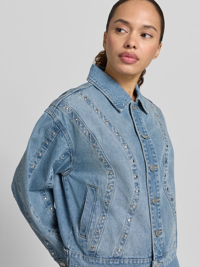 Frauenmodel trägt Jeansjacke mit Nieten und Eingrifftaschen Modell 'CLIO' von YAS, Reine Baumwolle, Relaxed-Fit, Nahaufnahme Oberkörper.