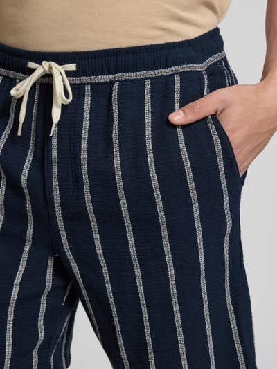 Männermodel trägt Regular Fit Shorts mit Tunnelzug von Jack & Jones aus reiner Baumwolle mit Gesäßtasche, Nahaufnahme Hüfte.