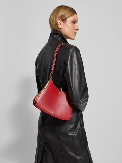 Frauenmodel trägt Handtasche mit Tragehenkel von Rabanne in Rot mit Label-Print, Hakenverschluss, Hauptfach, Innenfach mit Reißverschluss, Breite 21 cm, Länge 21 cm, Tiefe 11 cm, Ganzkörperansicht Rückansicht.