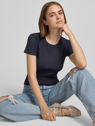 Frauenmodel trägt Regular Fit T-Shirt aus Baumwoll-Mix Modell 'VAL' von ONLY in Dunkelblau, kombiniert mit hellblauer Jeans, Nahaufnahme Oberkörper. Damen T-Shirt von ONLY.