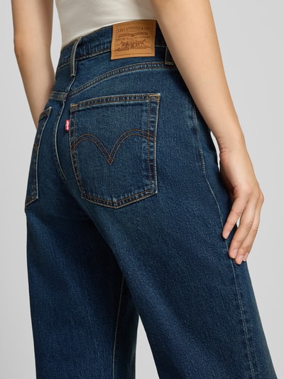 Frauenmodel trägt Bootcut Jeans aus Baumwoll-Mix Modell 'RIBCAGE FLARE' von Levi's® 300, dunkles Blau, sichtbare Nähte, Nahaufnahme Rückansicht.