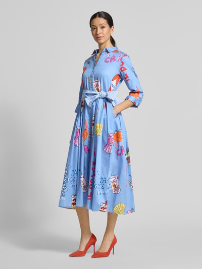 Frauenmodel trägt blaues Hemdblusenkleid mit Bindegürtel von Milano Italy aus Reine Baumwolle, Allover-Look, Taillierter Schnitt, Midikleid, Hemdblusenkragen, Ganzkörperansicht von vorne.