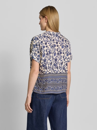 Frauenmodel trägt Relaxed Fit Bluse aus Viskose im Allover-Look Modell 'Mya' von LOLLYS LAUNDRY mit blauem Blumenmuster, Rückansicht, Rückenlänge 59 cm, Ärmellänge 15 cm, Rundhalsausschnitt, reine Viskose, Struktur sanft und leicht. Ganzkörperansicht Rückansicht.